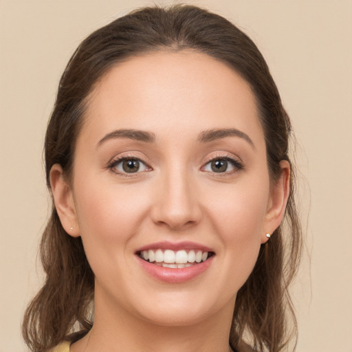 Joyful white young-adult female with long  brown hair and green eyes