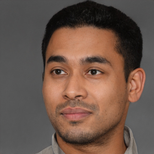 Joyful latino young-adult male with short  black hair and brown eyes