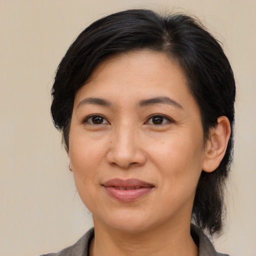Joyful asian adult female with medium  brown hair and brown eyes