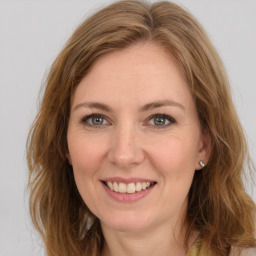 Joyful white young-adult female with long  brown hair and green eyes