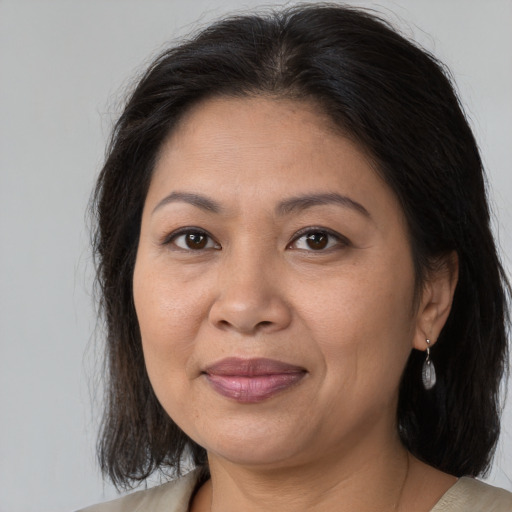 Joyful latino adult female with medium  brown hair and brown eyes