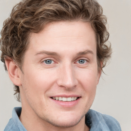 Joyful white young-adult male with short  brown hair and blue eyes