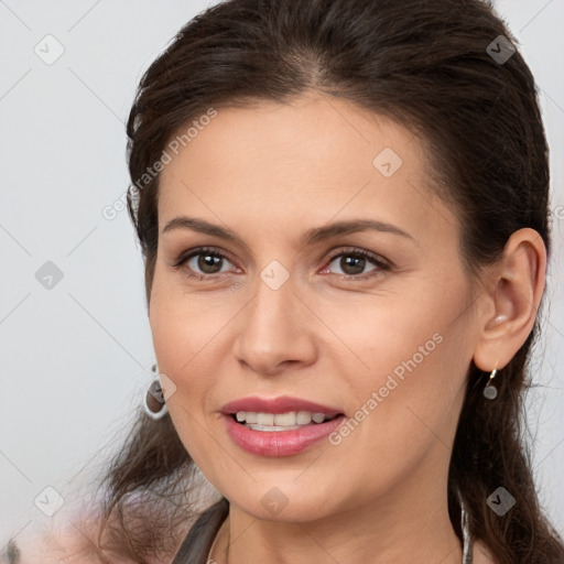 Joyful white young-adult female with long  brown hair and brown eyes