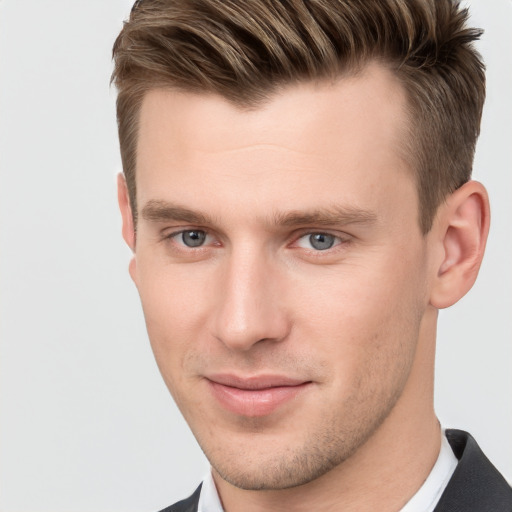 Joyful white young-adult male with short  brown hair and grey eyes