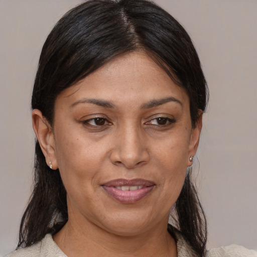 Joyful latino adult female with medium  brown hair and brown eyes