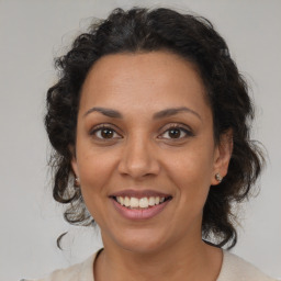 Joyful latino adult female with medium  brown hair and brown eyes