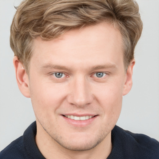 Joyful white young-adult male with short  brown hair and blue eyes