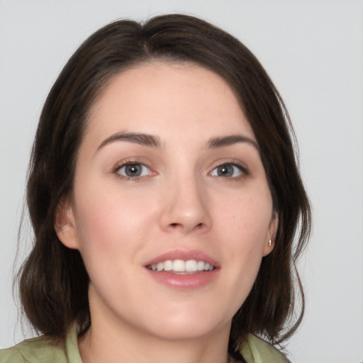 Joyful white young-adult female with medium  brown hair and green eyes