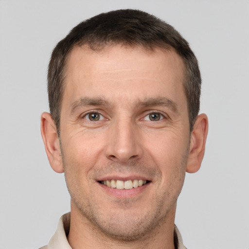 Joyful white adult male with short  brown hair and brown eyes