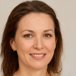 Joyful white adult female with long  brown hair and green eyes