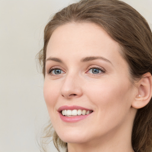 Joyful white young-adult female with medium  brown hair and green eyes