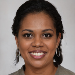 Joyful black young-adult female with medium  brown hair and brown eyes