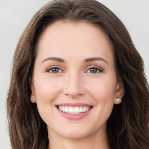 Joyful white young-adult female with long  brown hair and grey eyes