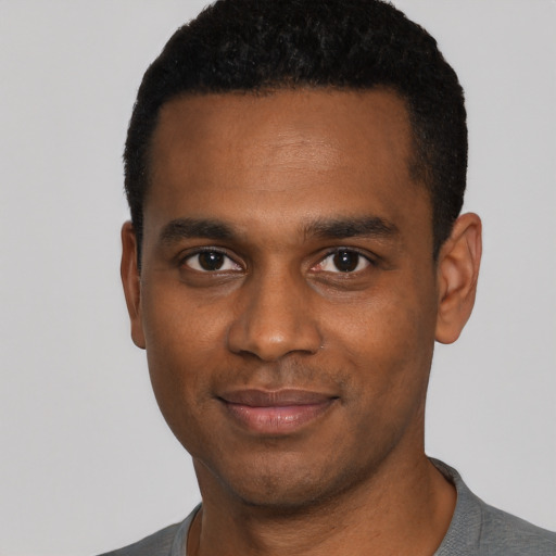 Joyful black young-adult male with short  black hair and brown eyes