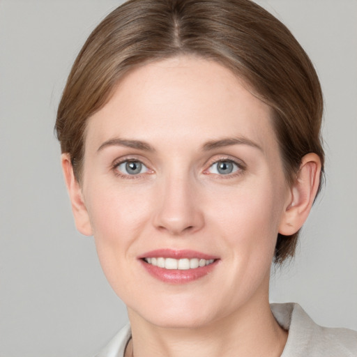 Joyful white young-adult female with medium  brown hair and grey eyes