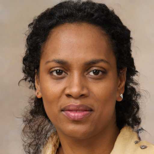 Joyful black adult female with medium  brown hair and brown eyes