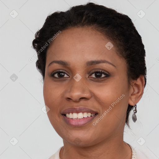 Joyful black young-adult female with short  brown hair and brown eyes