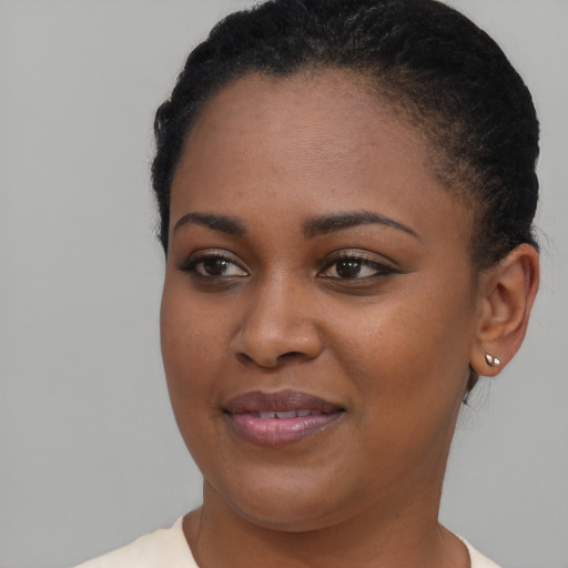 Joyful black young-adult female with short  brown hair and brown eyes