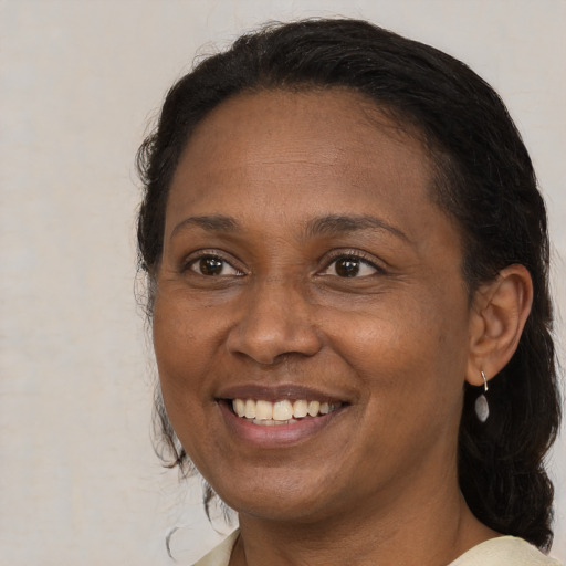 Joyful black adult female with medium  brown hair and brown eyes