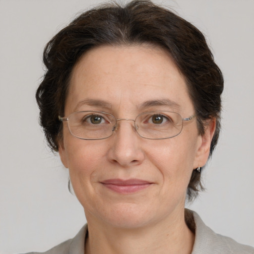 Joyful white adult female with medium  brown hair and green eyes