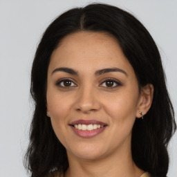 Joyful latino young-adult female with long  brown hair and brown eyes