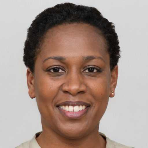 Joyful black adult female with short  black hair and brown eyes