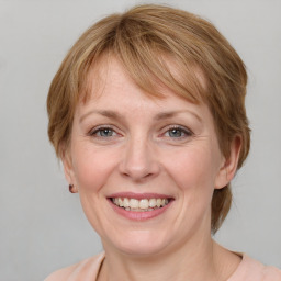 Joyful white adult female with medium  brown hair and blue eyes