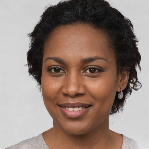 Joyful black young-adult female with short  brown hair and brown eyes