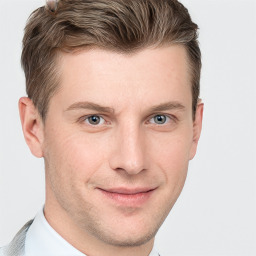 Joyful white young-adult male with short  brown hair and grey eyes