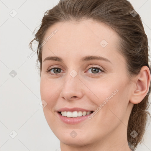 Joyful white young-adult female with long  brown hair and blue eyes