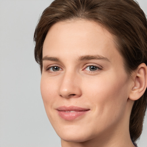 Joyful white young-adult female with medium  brown hair and grey eyes