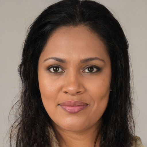 Joyful black young-adult female with long  brown hair and brown eyes