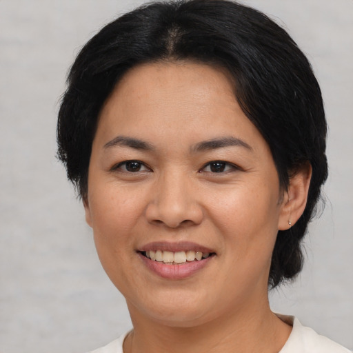Joyful asian young-adult female with short  black hair and brown eyes