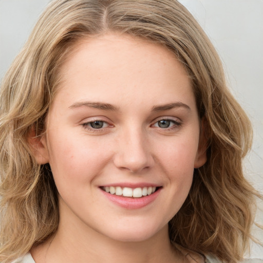 Joyful white young-adult female with long  brown hair and green eyes