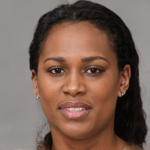 Joyful black young-adult female with short  black hair and brown eyes