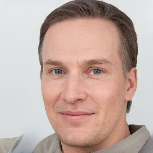 Joyful white adult male with short  brown hair and grey eyes