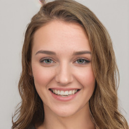 Joyful white young-adult female with long  brown hair and green eyes