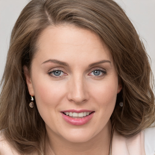 Joyful white young-adult female with long  brown hair and grey eyes