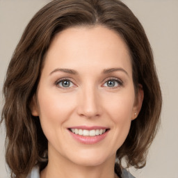 Joyful white young-adult female with medium  brown hair and green eyes