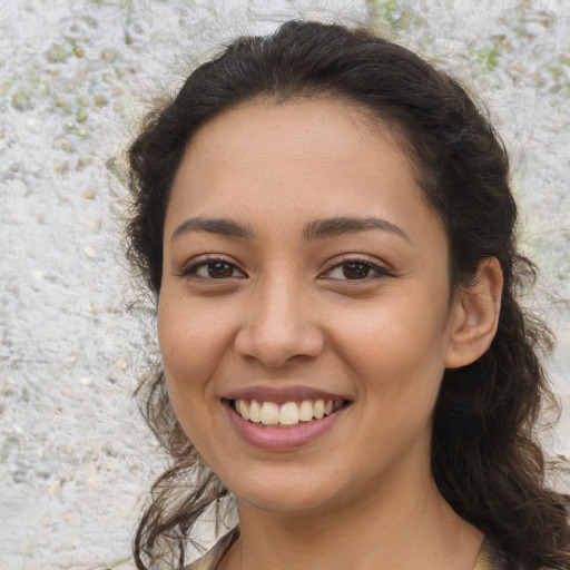 Joyful latino young-adult female with long  brown hair and brown eyes