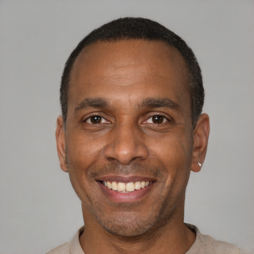 Joyful black adult male with short  brown hair and brown eyes