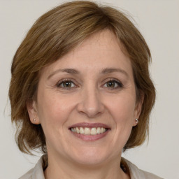 Joyful white adult female with medium  brown hair and grey eyes