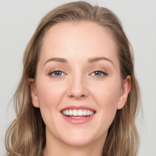 Joyful white young-adult female with long  brown hair and blue eyes