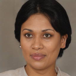 Joyful black adult female with medium  brown hair and brown eyes