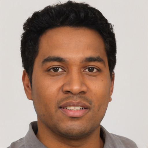 Joyful latino young-adult male with short  black hair and brown eyes
