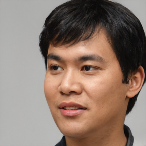 Joyful asian young-adult male with short  black hair and brown eyes
