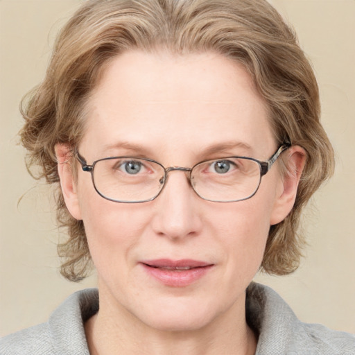 Joyful white adult female with medium  brown hair and blue eyes