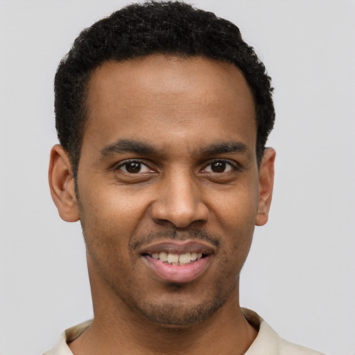 Joyful black young-adult male with short  brown hair and brown eyes