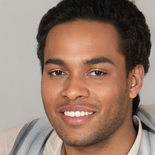 Joyful black young-adult male with short  brown hair and brown eyes