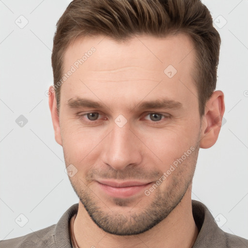 Joyful white young-adult male with short  brown hair and grey eyes